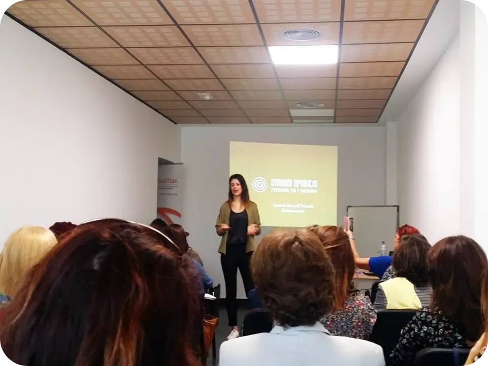 Miriam Aparicio impartiendo una conferencia ante un grupo de mujeres