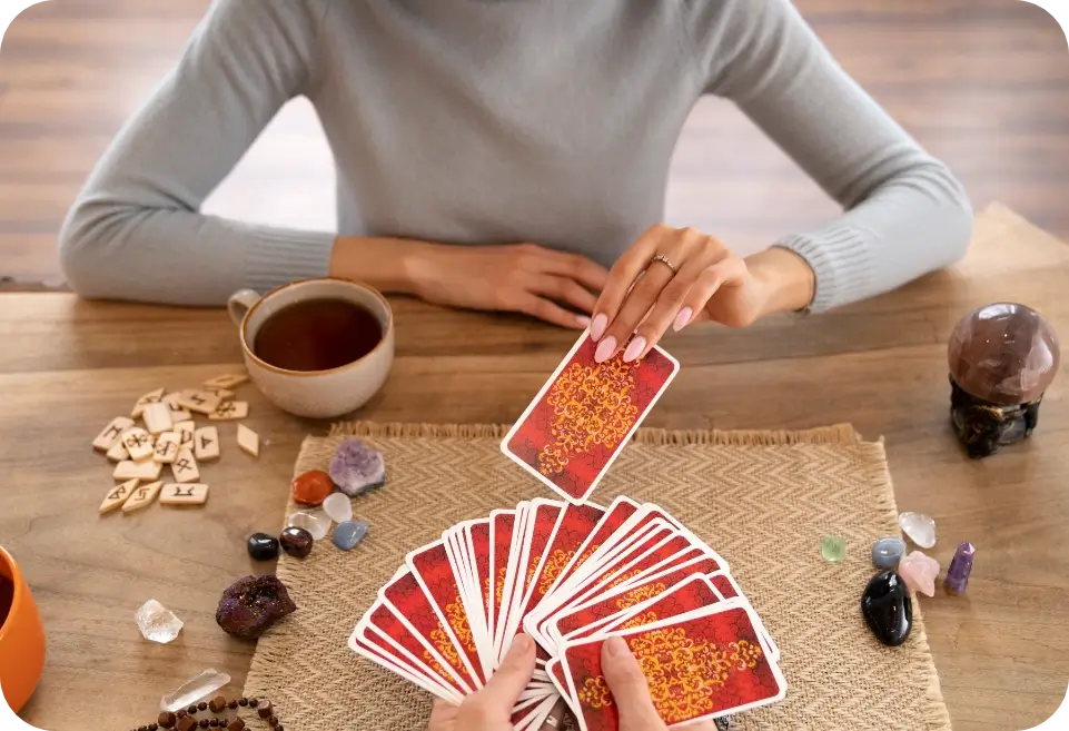 Consulta de cartas sobre una mesa de madera con una taza de té y piedras