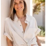 Miriam Aparicio, terapeuta, sonriendo apoyada en una pared luminosa