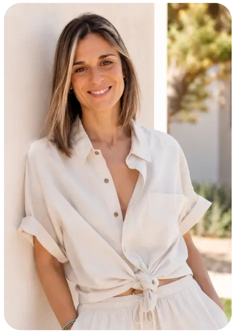 Miriam Aparicio, terapeuta, sonriendo apoyada en una pared luminosa